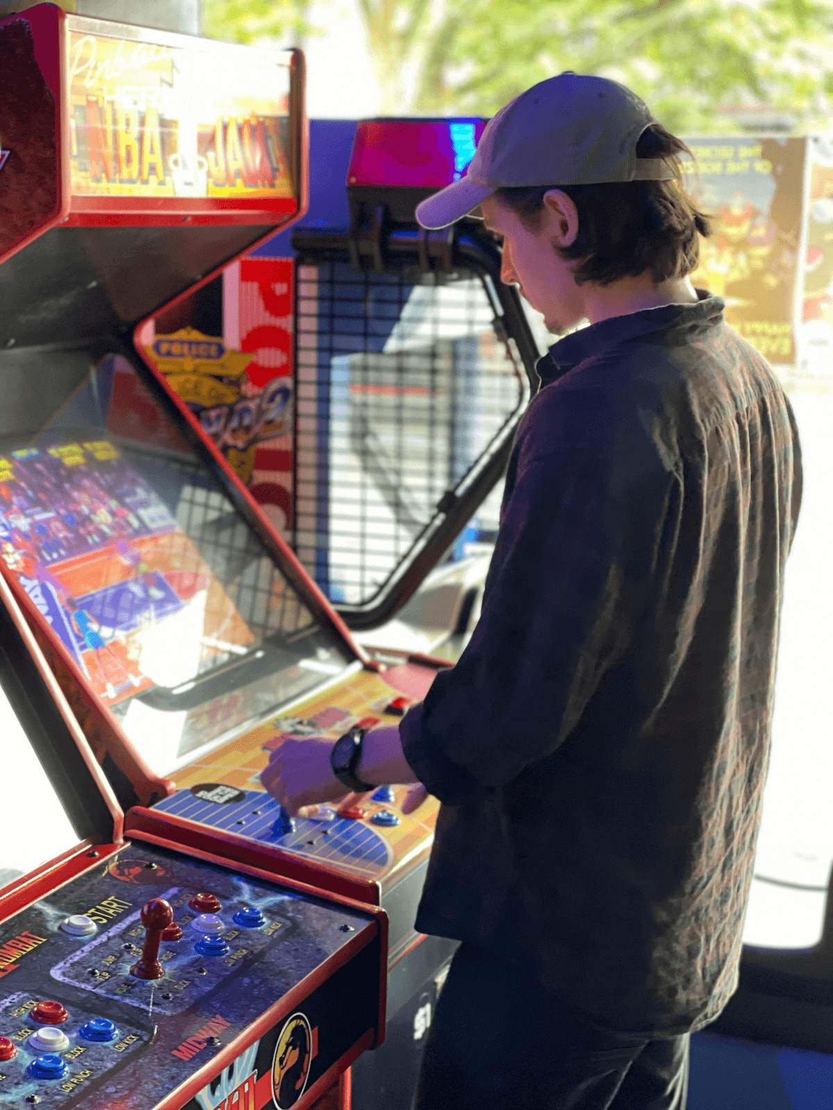 A photo of Alex Rapley playing NBA Jam on an arcade machine